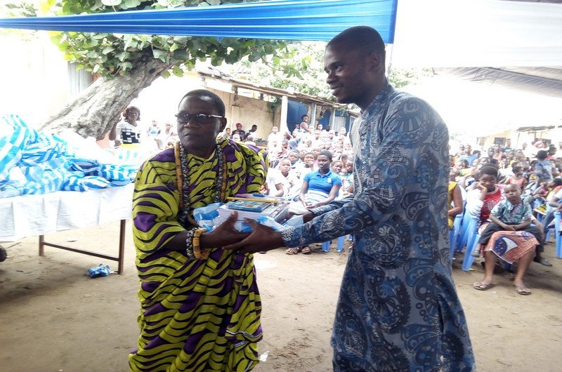Le chef du quartier remettant les kits à un élève d'Agodo-Atimé à Lomé