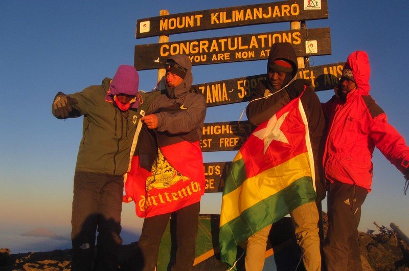 Severin Vias hisse le drapeau national sur le mont Kilimandjaro